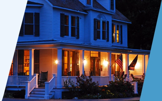 Home lit up at dusk with American flags