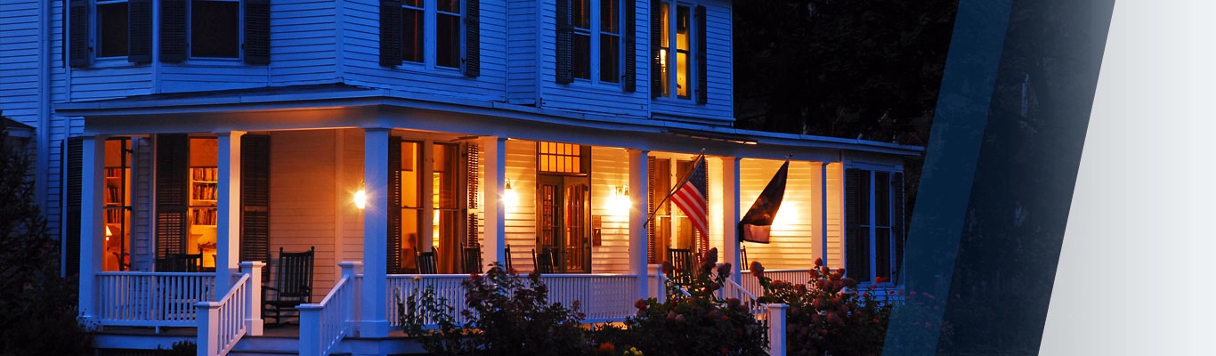 Home lit up at dusk with American flags